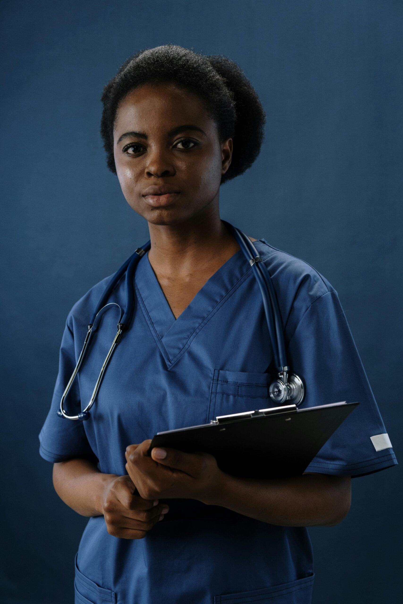 Professional nurse in blue scrubs holding a clipboard, conveying confidence and care.